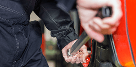 Worker adjusts the lug nut on the tire of an orange vehicle