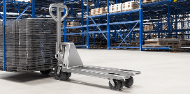 Manual pallet jack positioned in a warehouse aisle beside stacked pallets and blue storage racks.