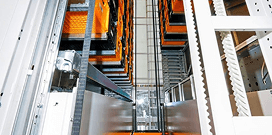 Interior view of an automated vertical storage system with stacked trays and mechanical lift components.