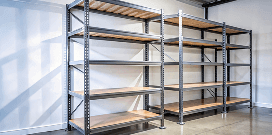 Two metal shelves sitting in the corner of a room in a warehouse