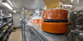 Parts wrapped in plastic sitting on a shelf in a warehouse